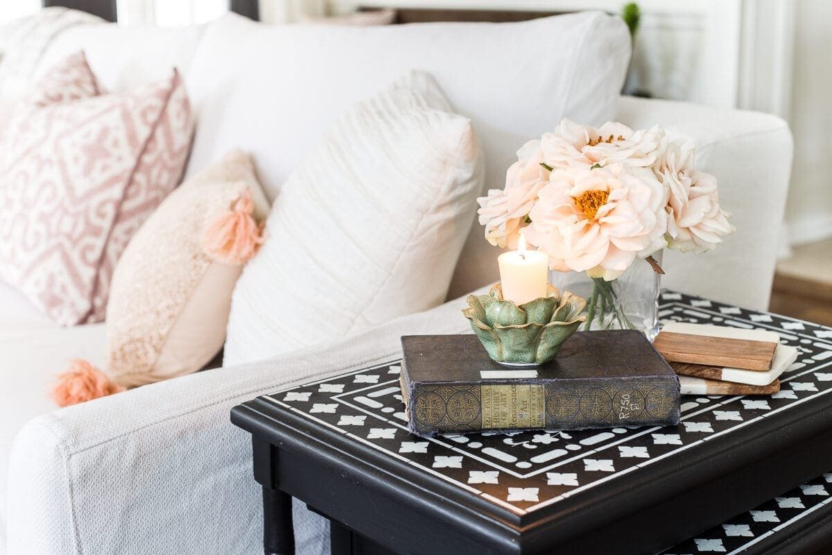 A living room gets a spring refresh with simple florals, candle light, and light fabrics. #springdecor #livingroom #springlivingroom #springaccents #livingroomdesign #livingroomdecor #budgetdecor