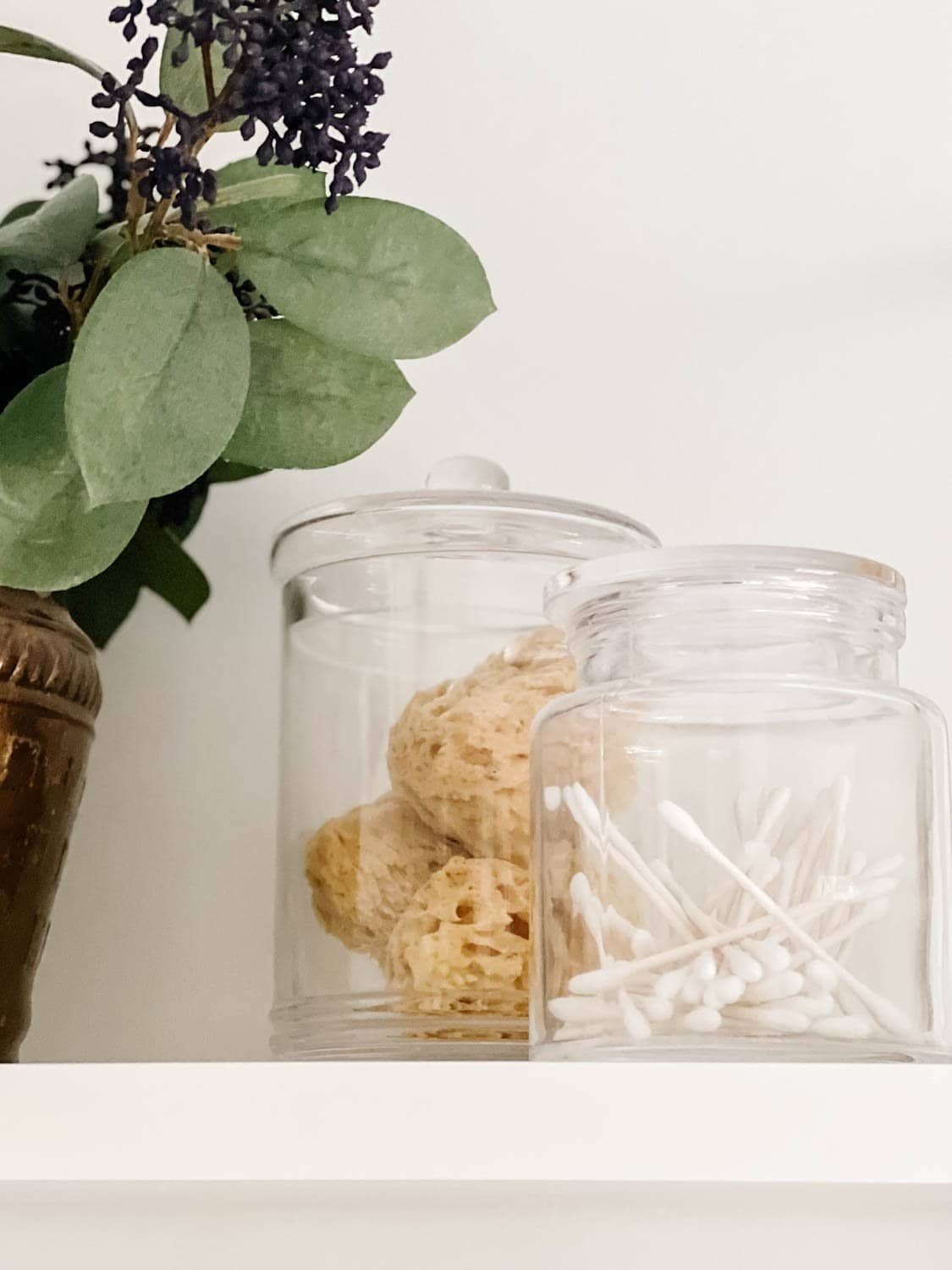 apothecary jars with q tips and bath sponges for spa bathroom storage