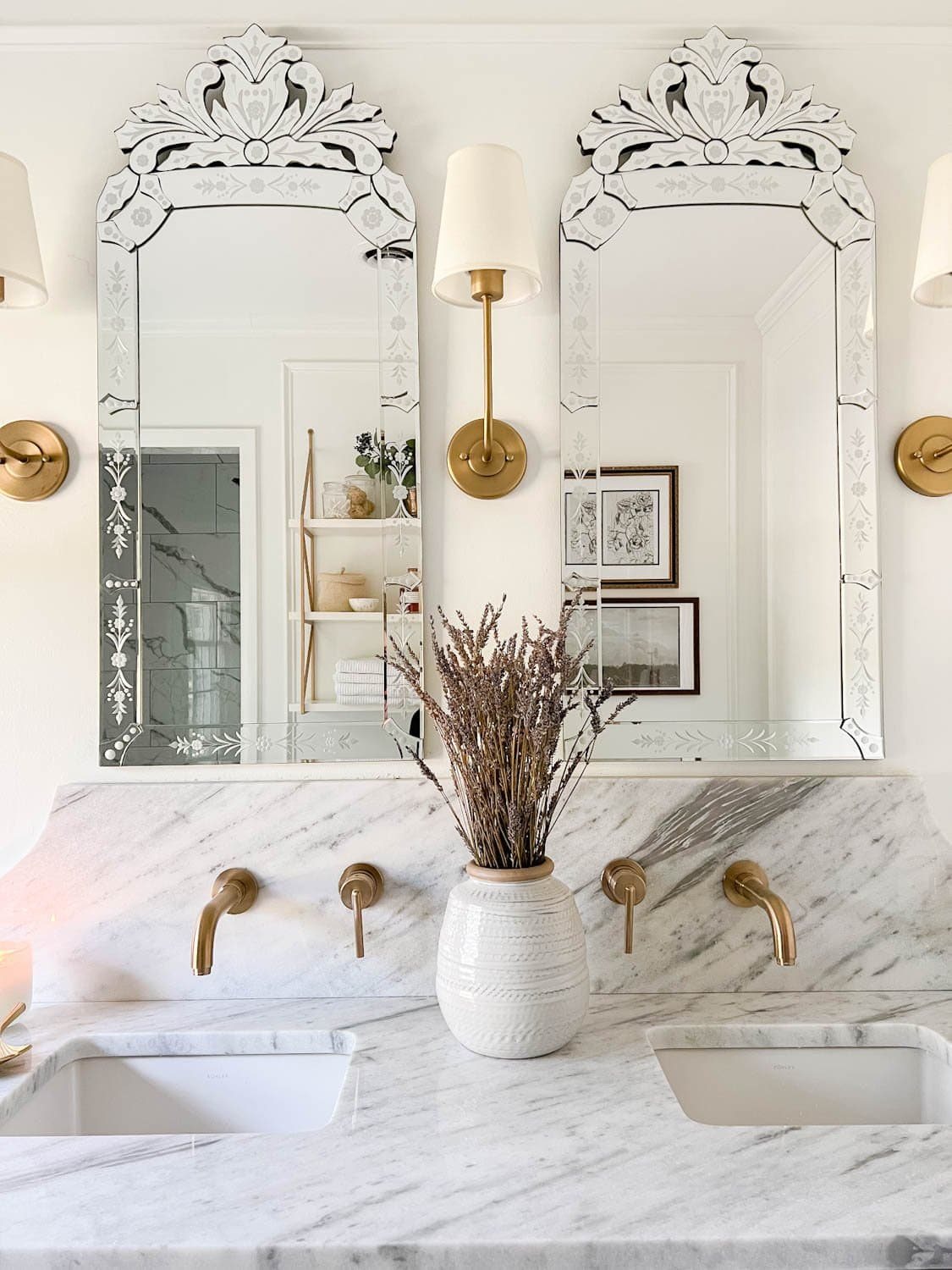Venetian mirrors, shaded sconces, and lavender in a vase for spa bathroom decor