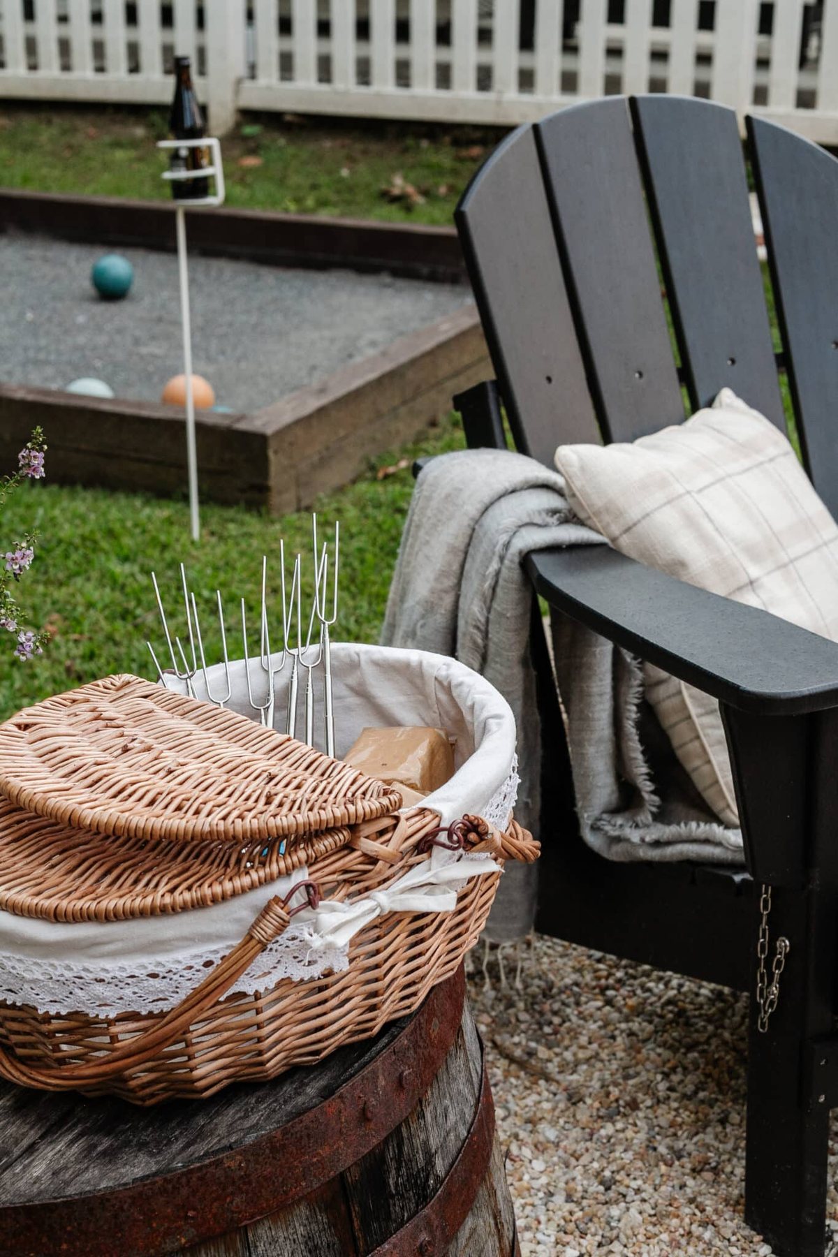 s'mores station setup in a picnic basket with ingredients and skewers