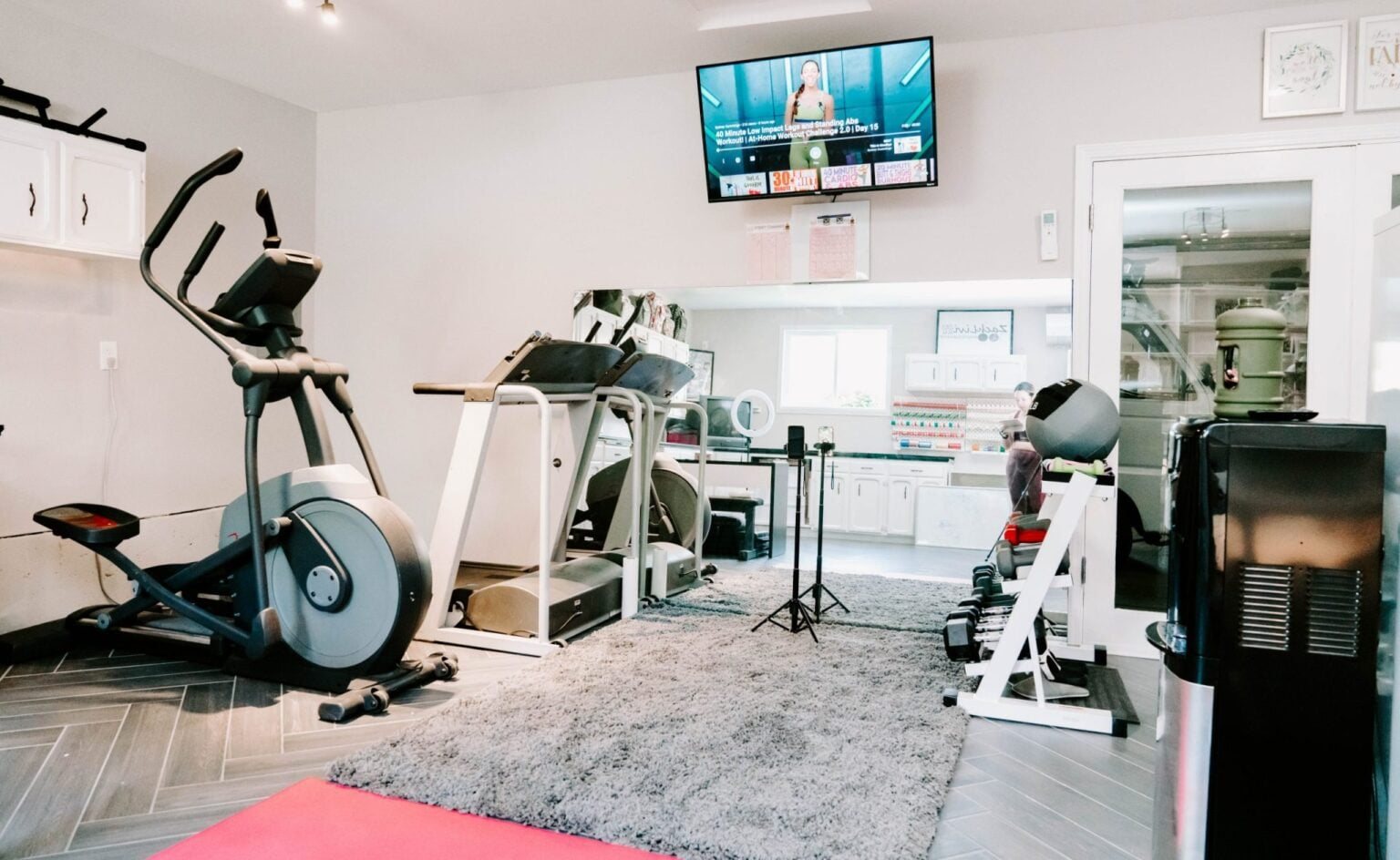 workout room with TV, large mirror, and rug