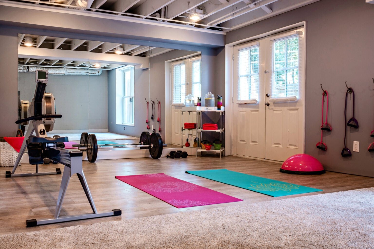 home gym with exposed ceiling and large mirrors