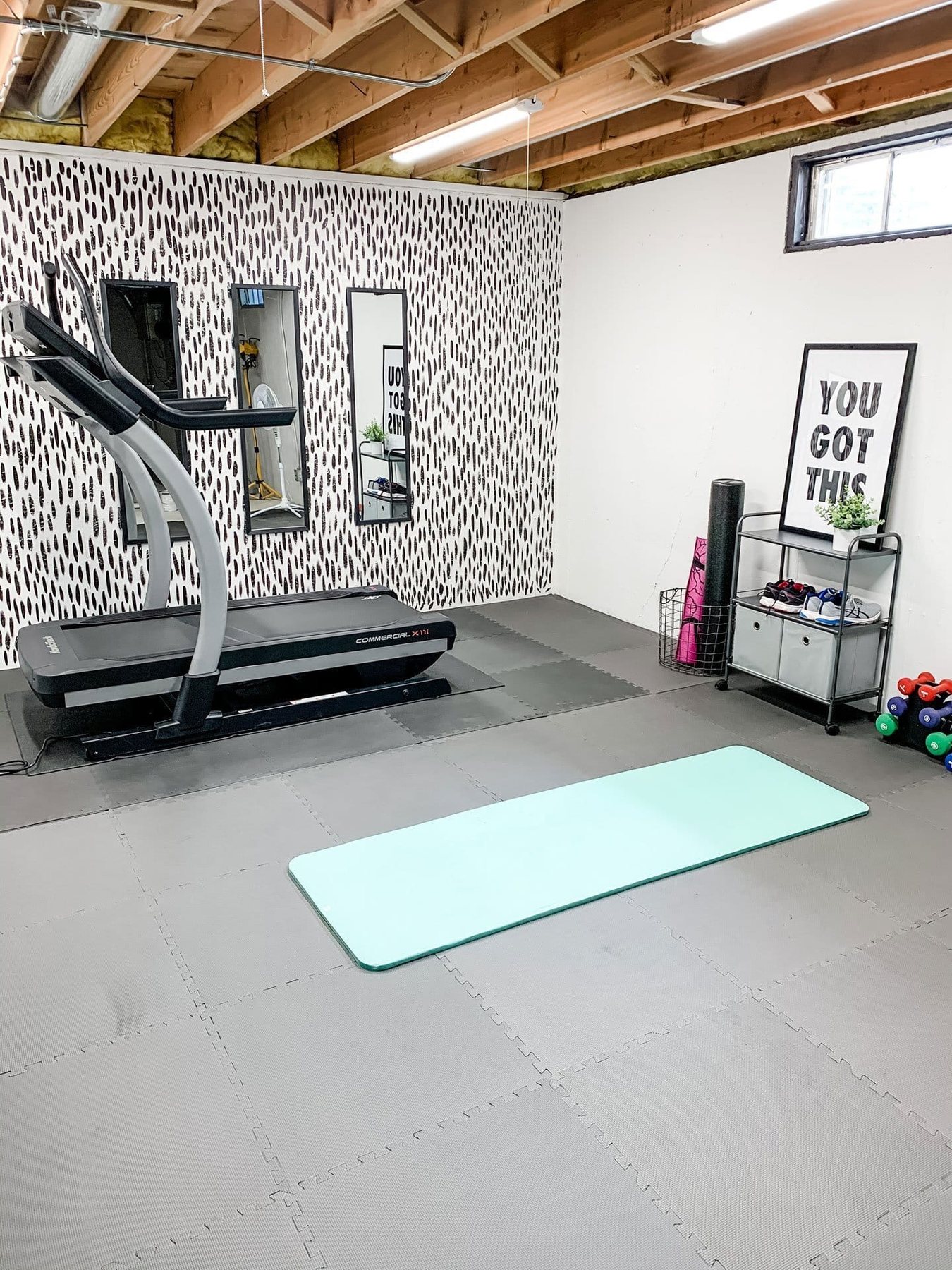 home gym with brushstroke accent wall in a basement