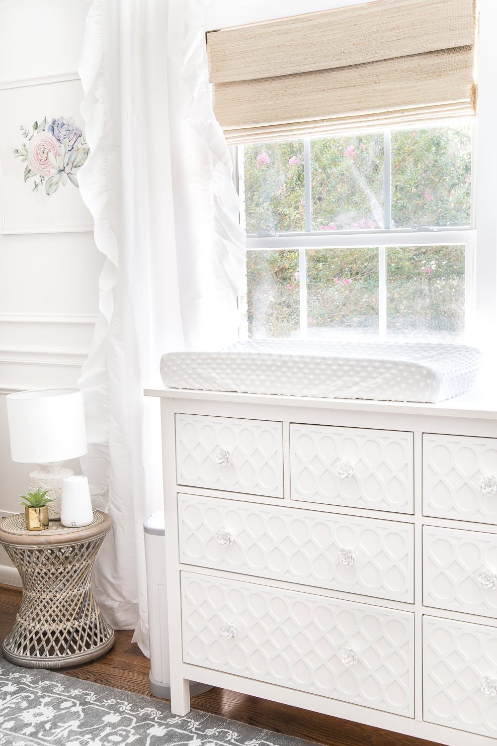 An all white nursery makeover room reveal with classic, vintage style furniture, Anthropologie-inspired patterns and textures, and floral accents.