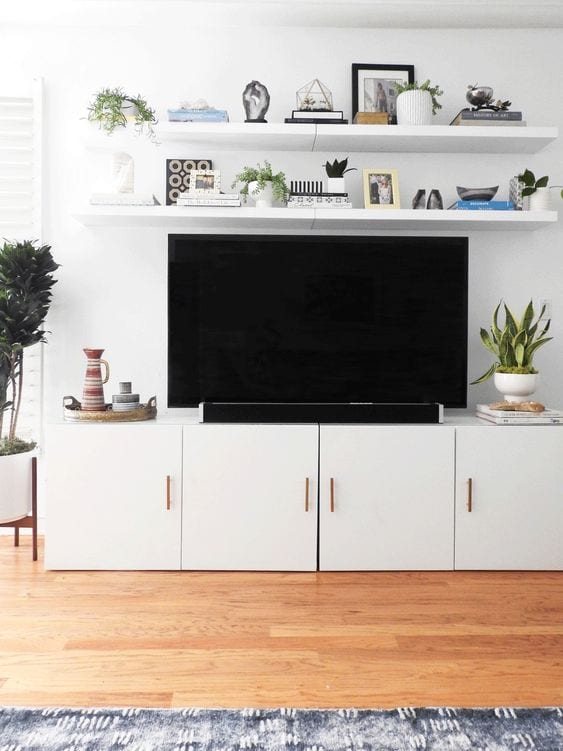 Add floating shelves above a TV for a built-in look on the cheap.