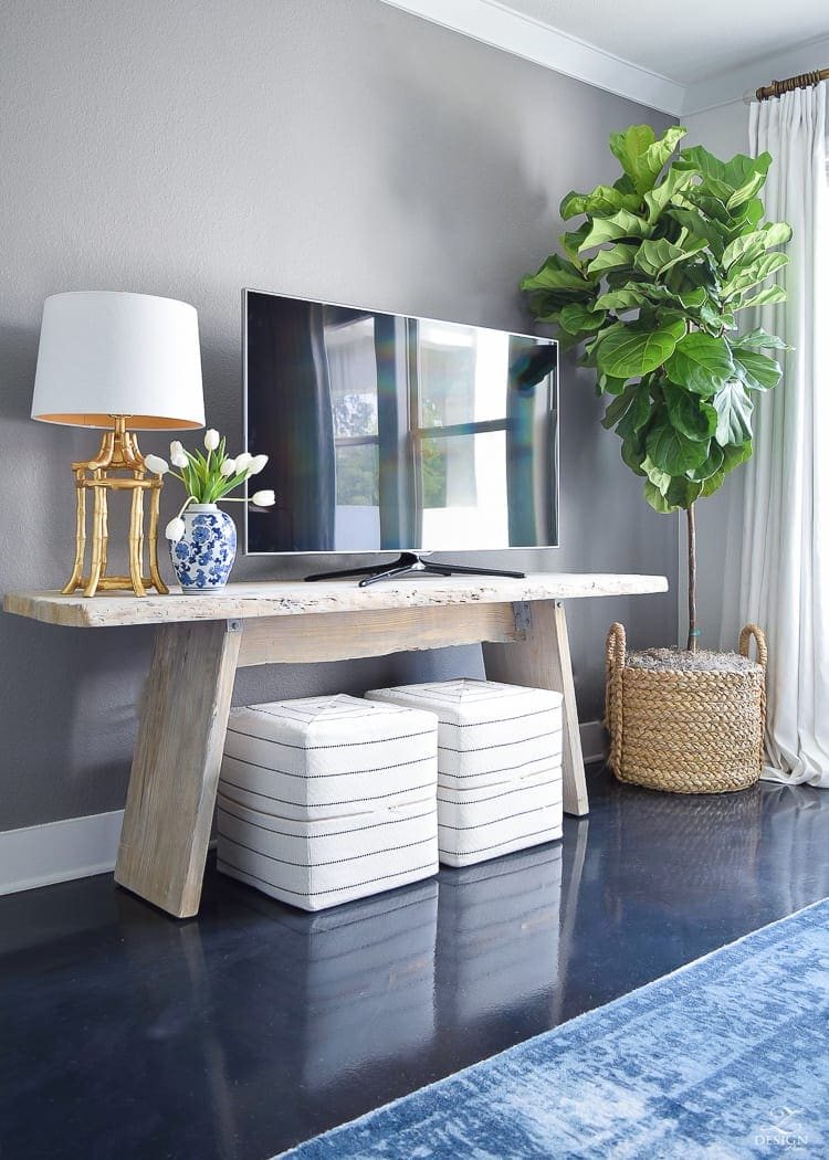 Add visual height beside a TV to distract from it. Add a floor lamp or a tall plant and suddenly that TV doesn't stick out quite so much.