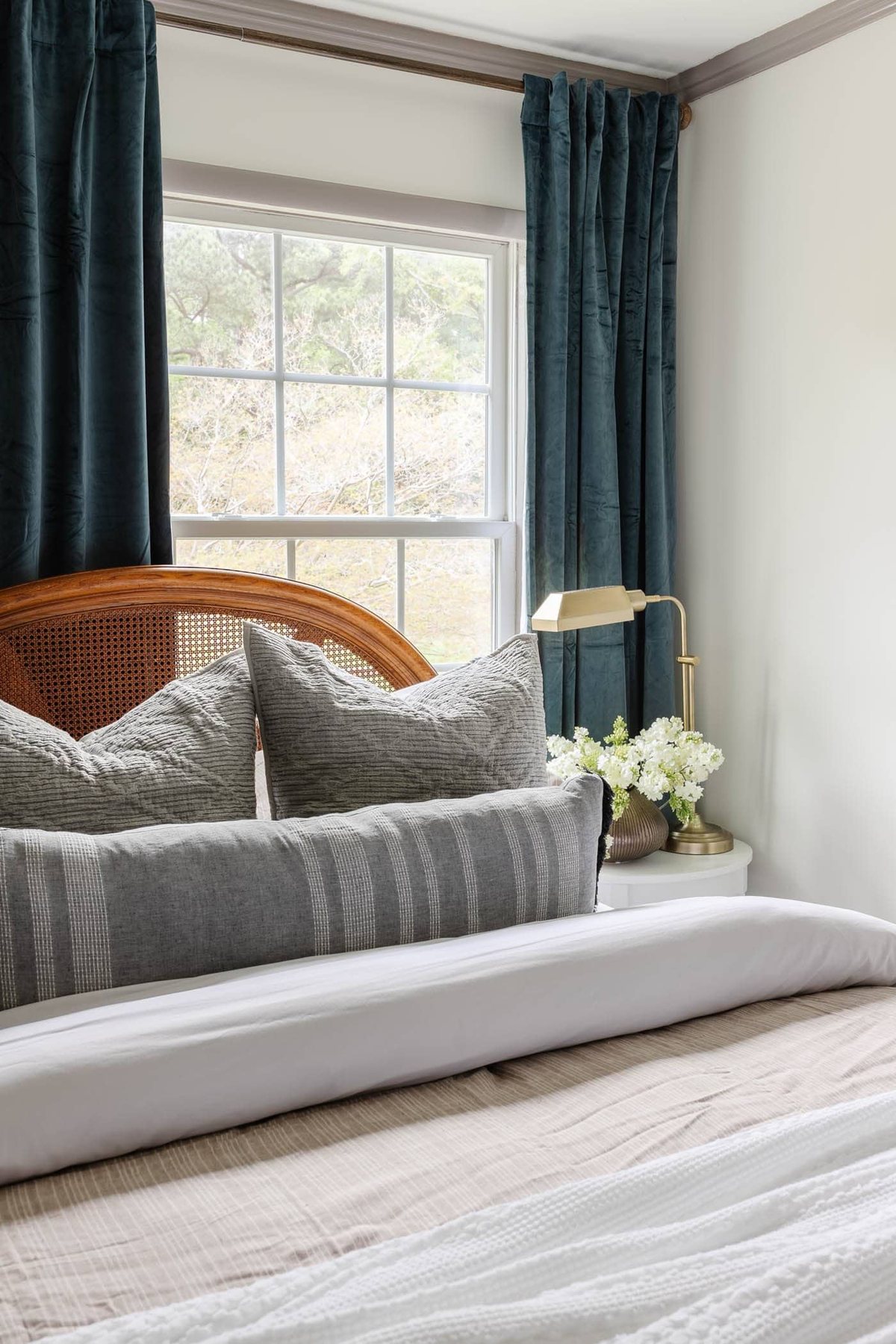blue curtains and cane bed with neutral bedding for a classic interior design