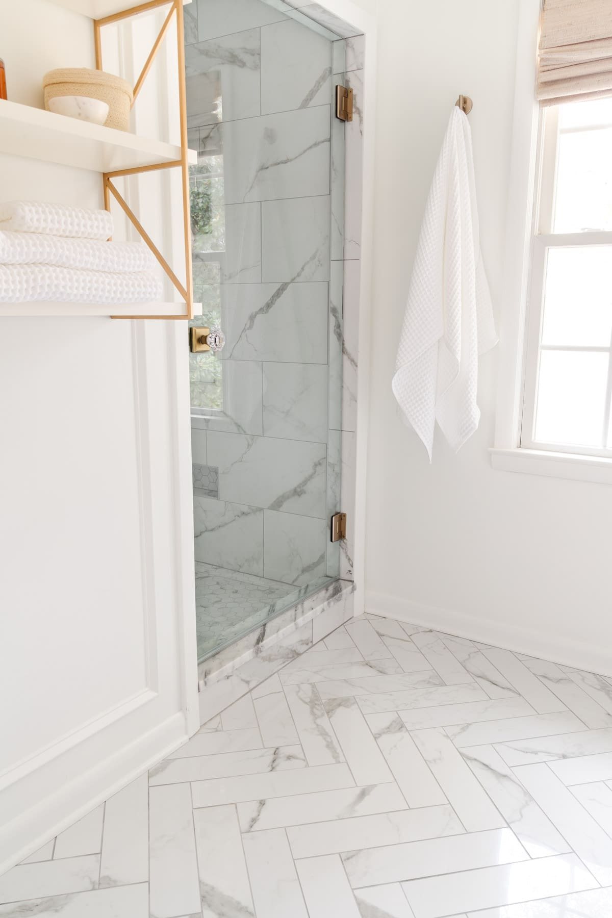 herringbone tile floors in a white bathroom