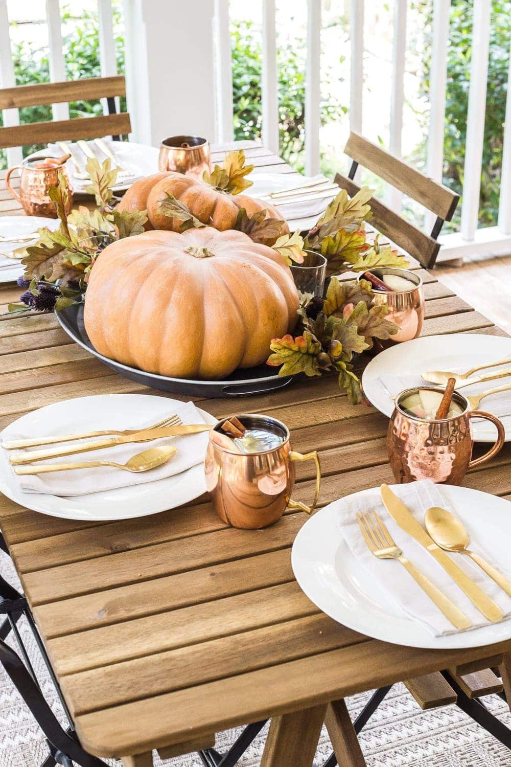 cozy fall porch with copper and pumpkin tablescape