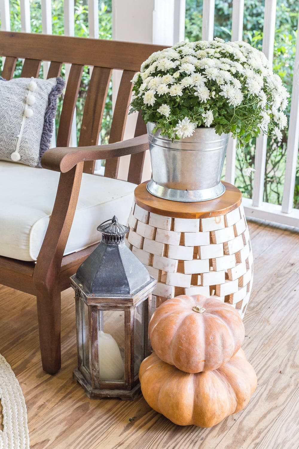cozy fall porch with lanterns, mums, and pumpkins
