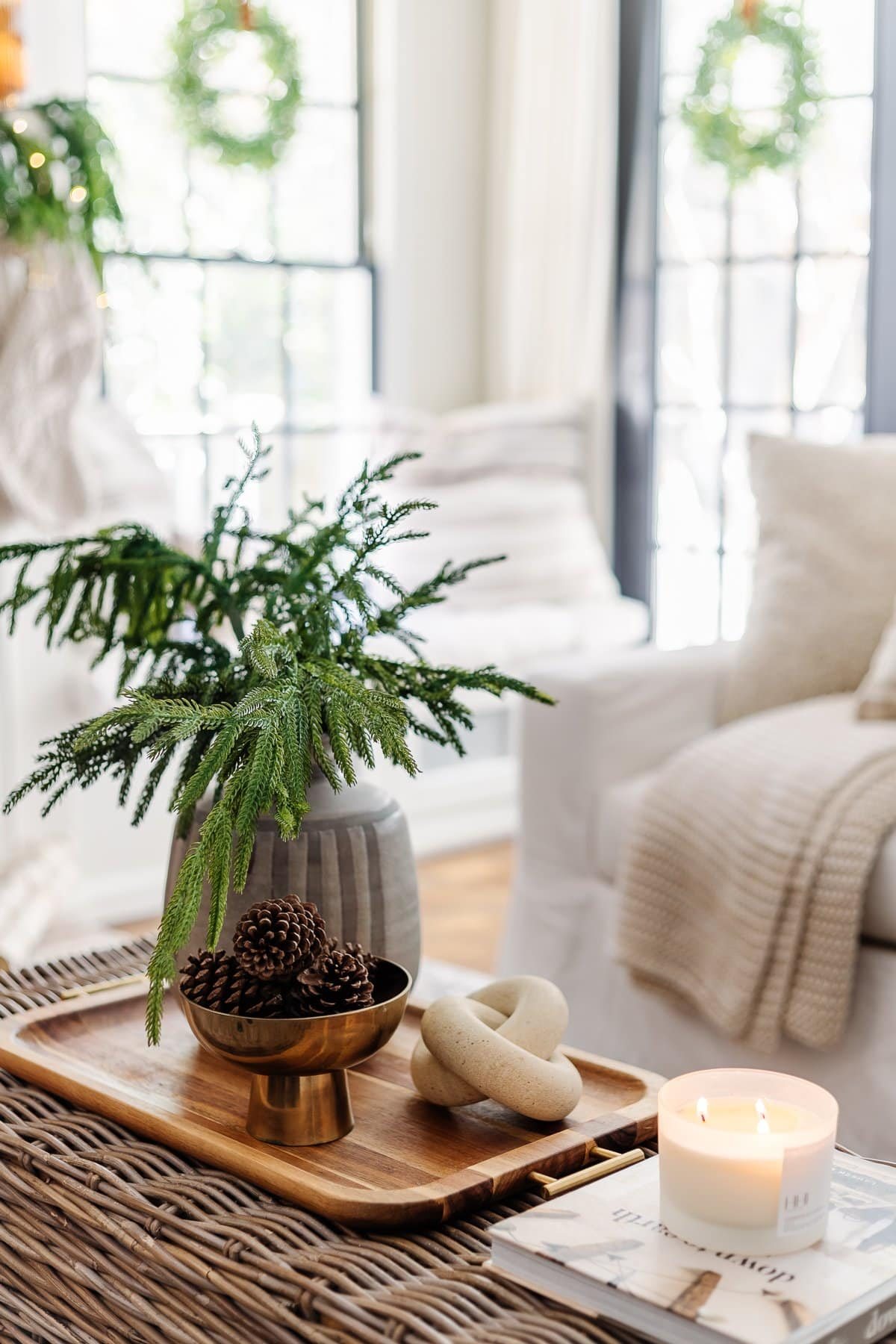 coffee table winter decor in a living room with bowl of pinecones and vase of evergreen stems