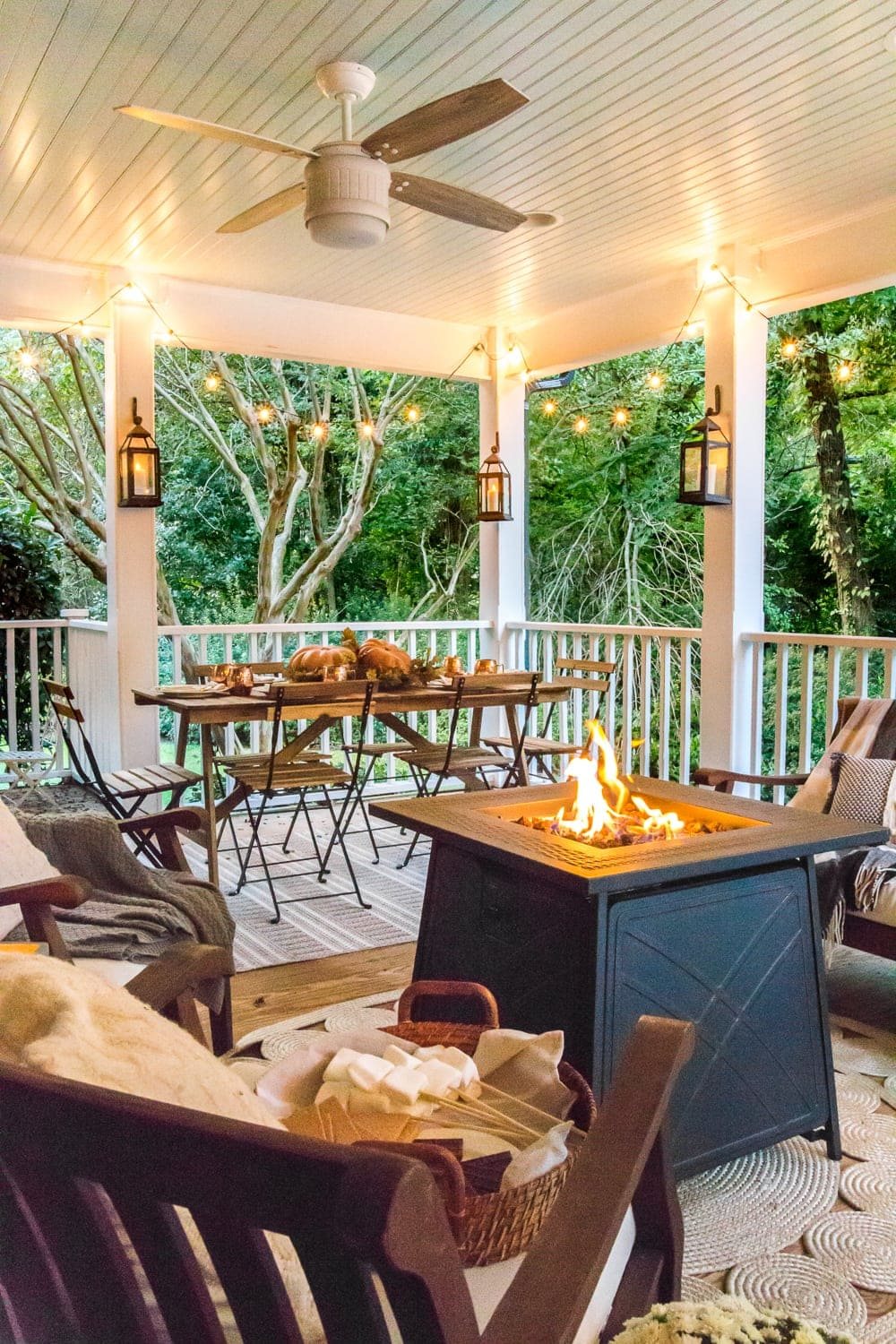 cozy fall porch with lanterns, string lights, and fire pit