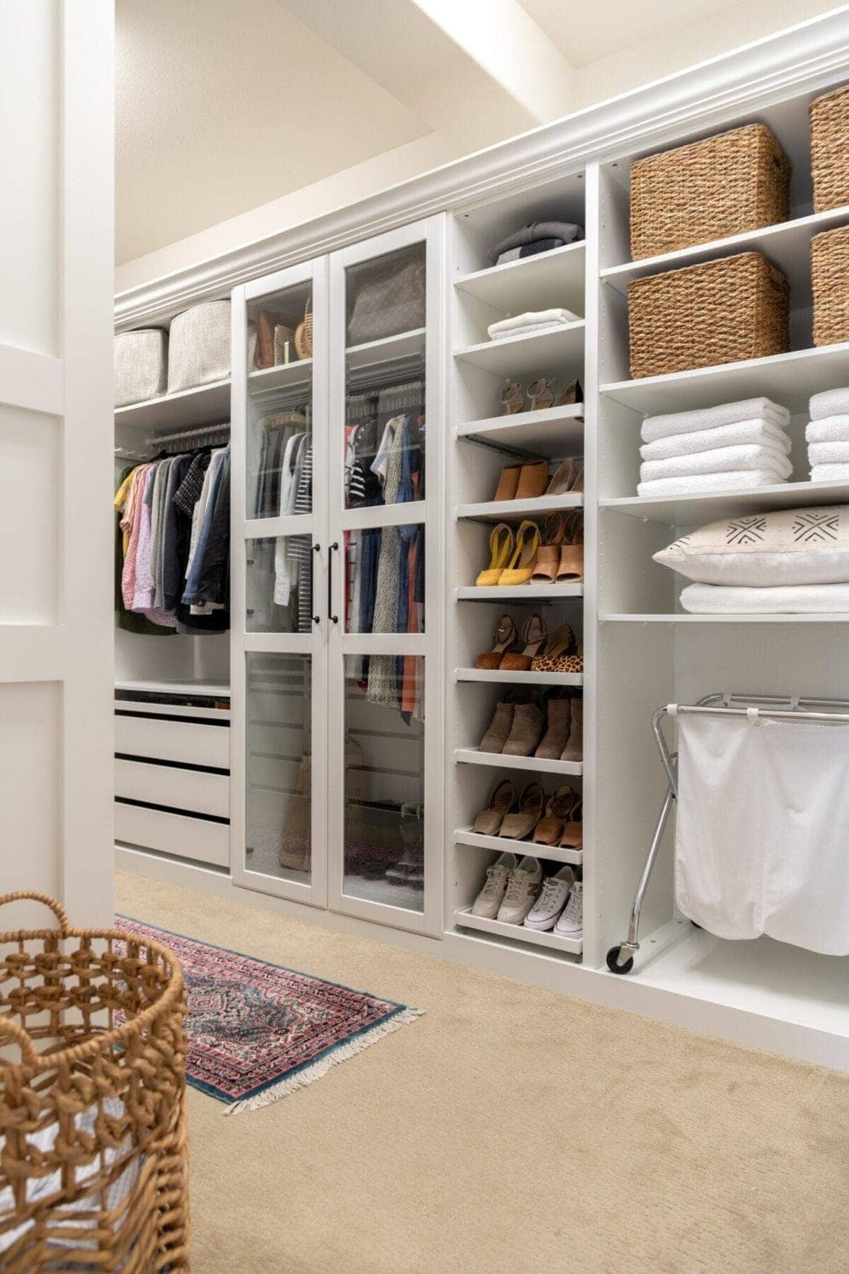 Closet with glass front doors shoe shelves and hamper