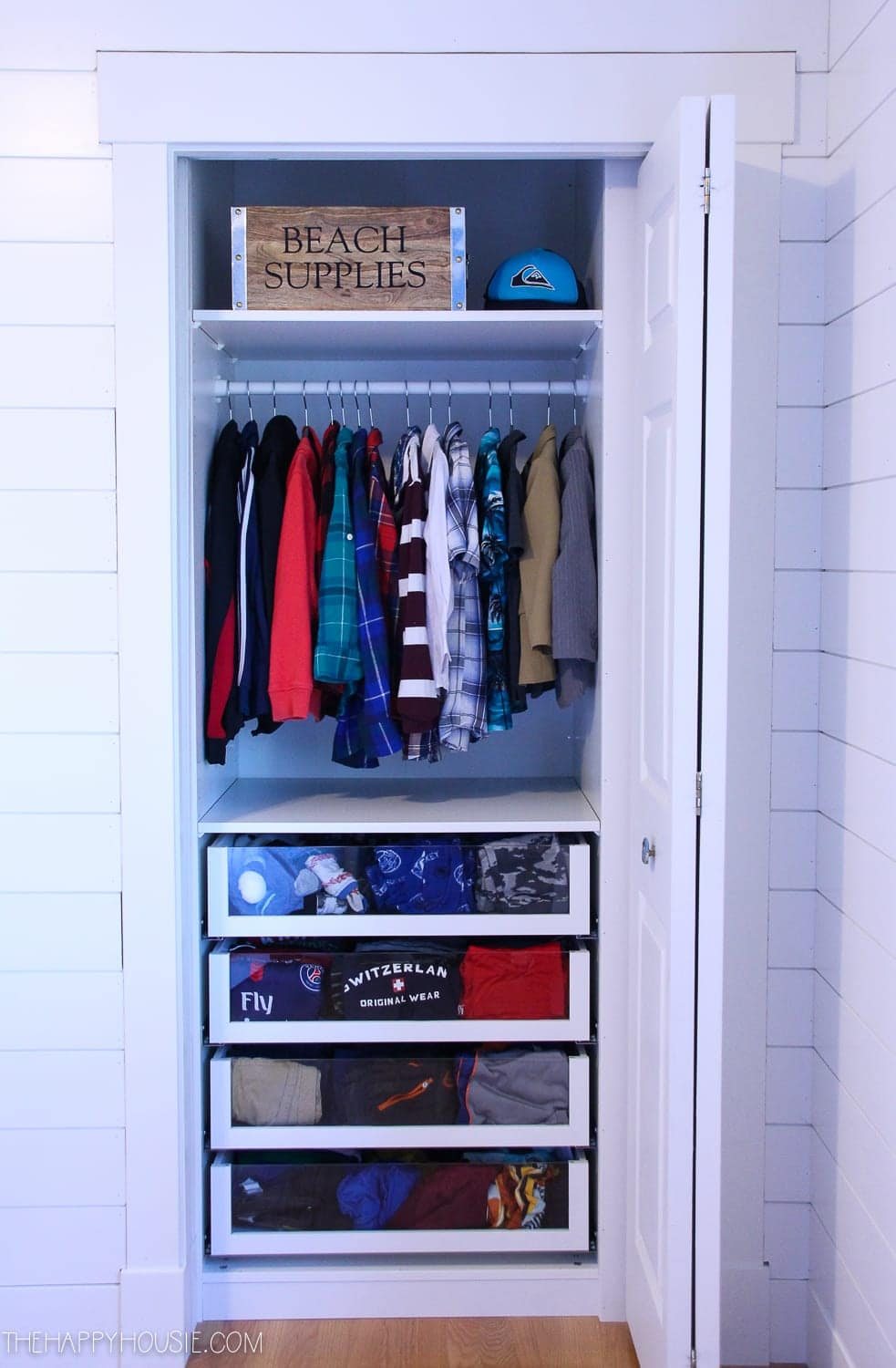 small reach in closet with clear drawer fronts