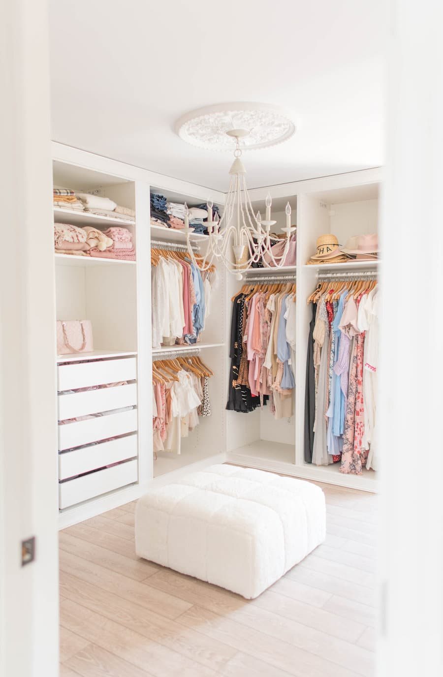 all white built in closet system with ottoman bench