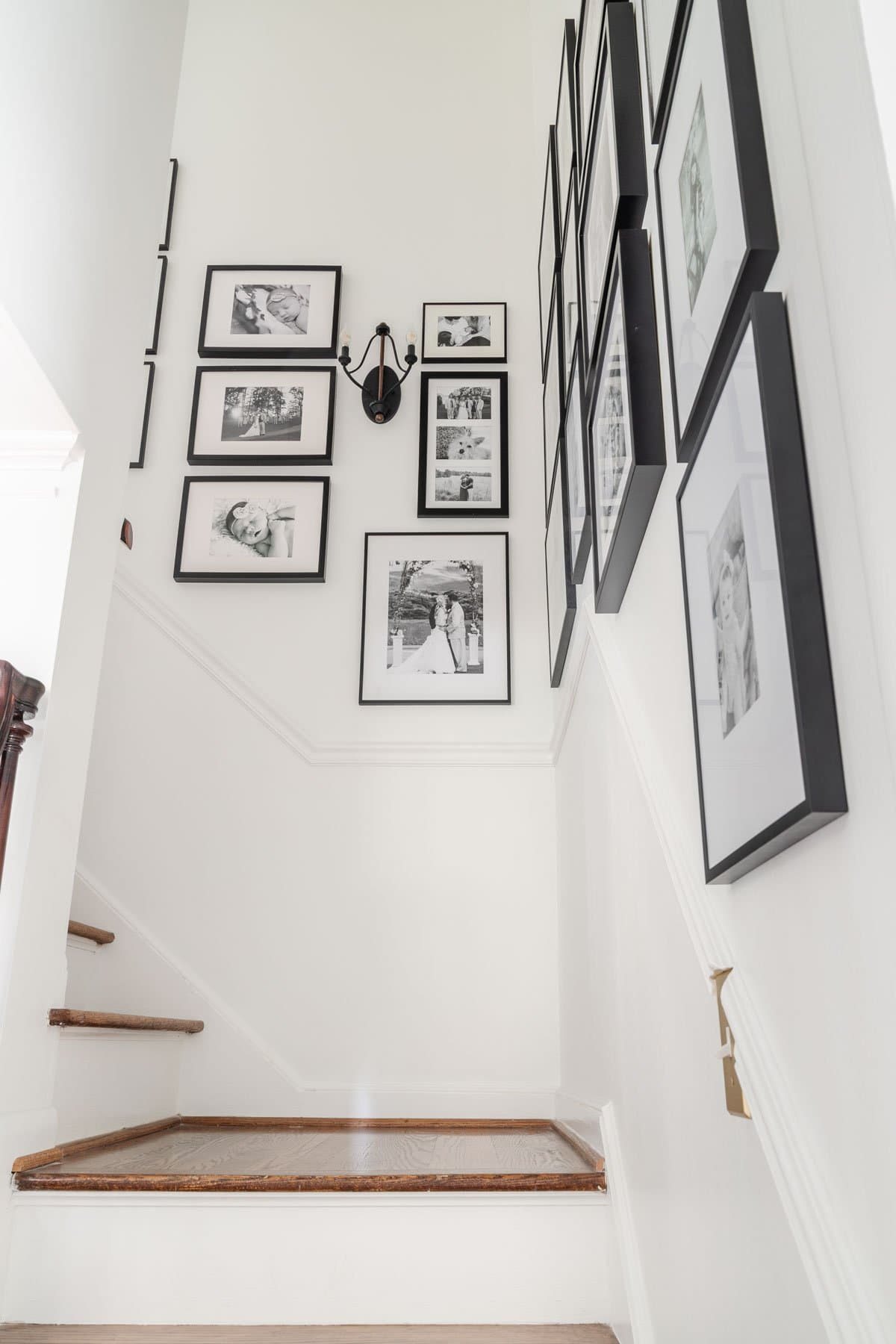black candelabra sconce on a gallery wall up a staircase