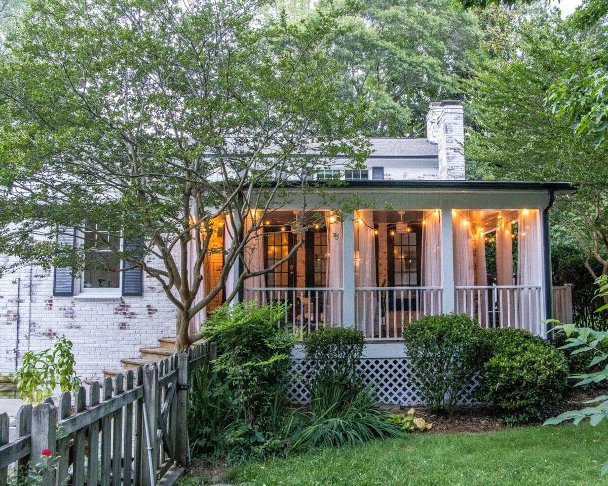 limewashed brick house exterior backyard with porch string lights