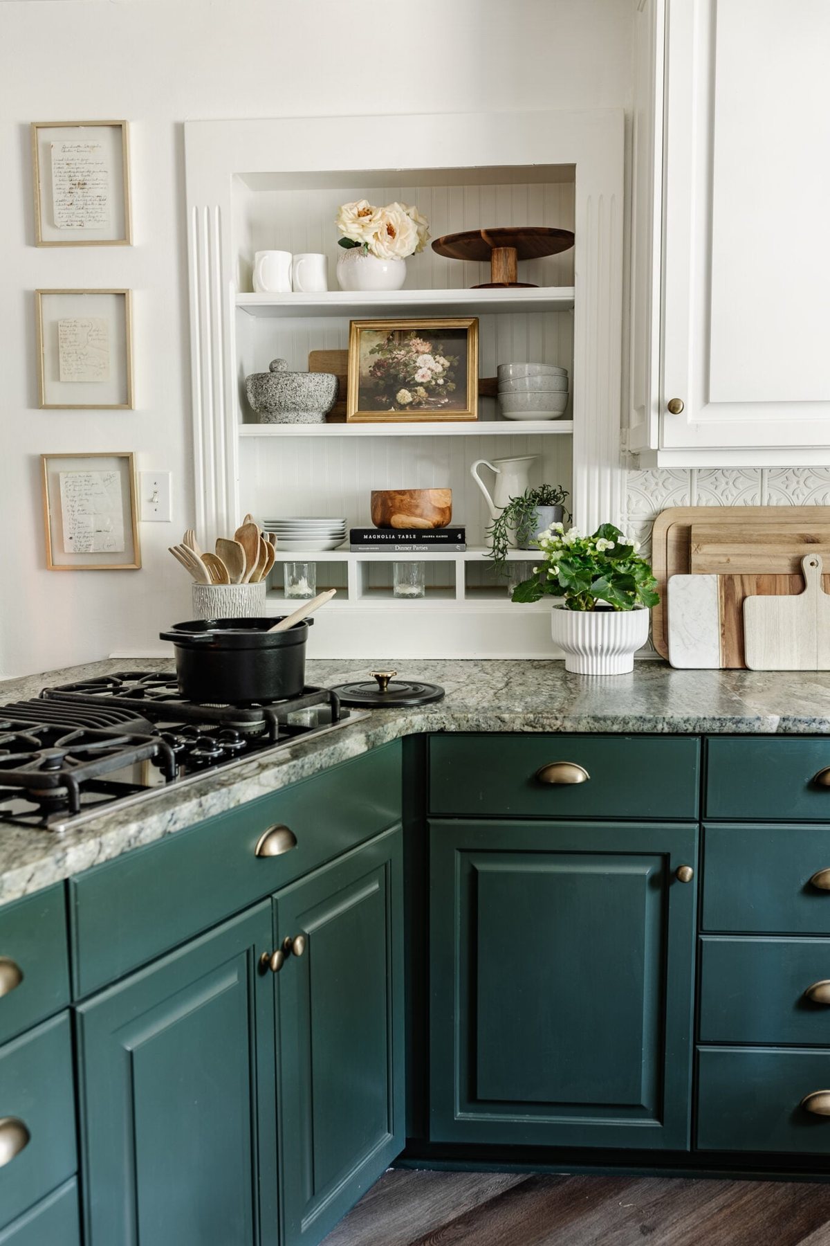kitchen open shelving with plates, bowls, serving ware, and art