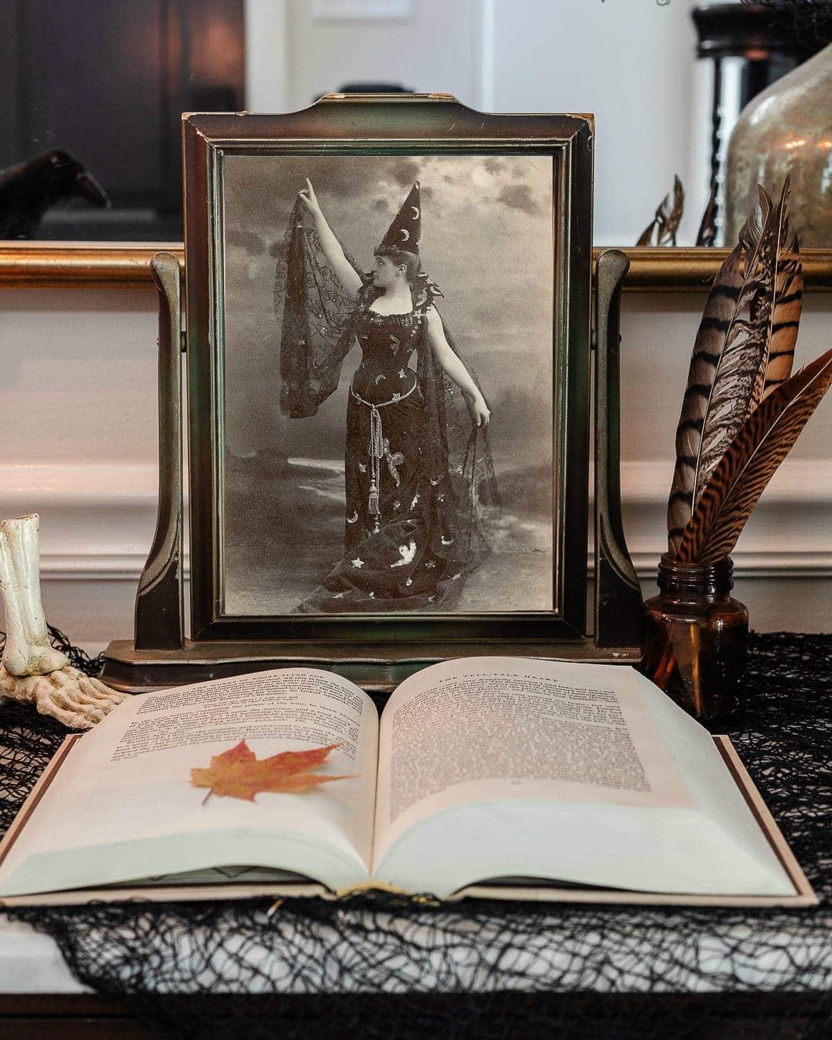 vintage halloween portrait art in an antique picture frame with old book, ink well, and black fabric