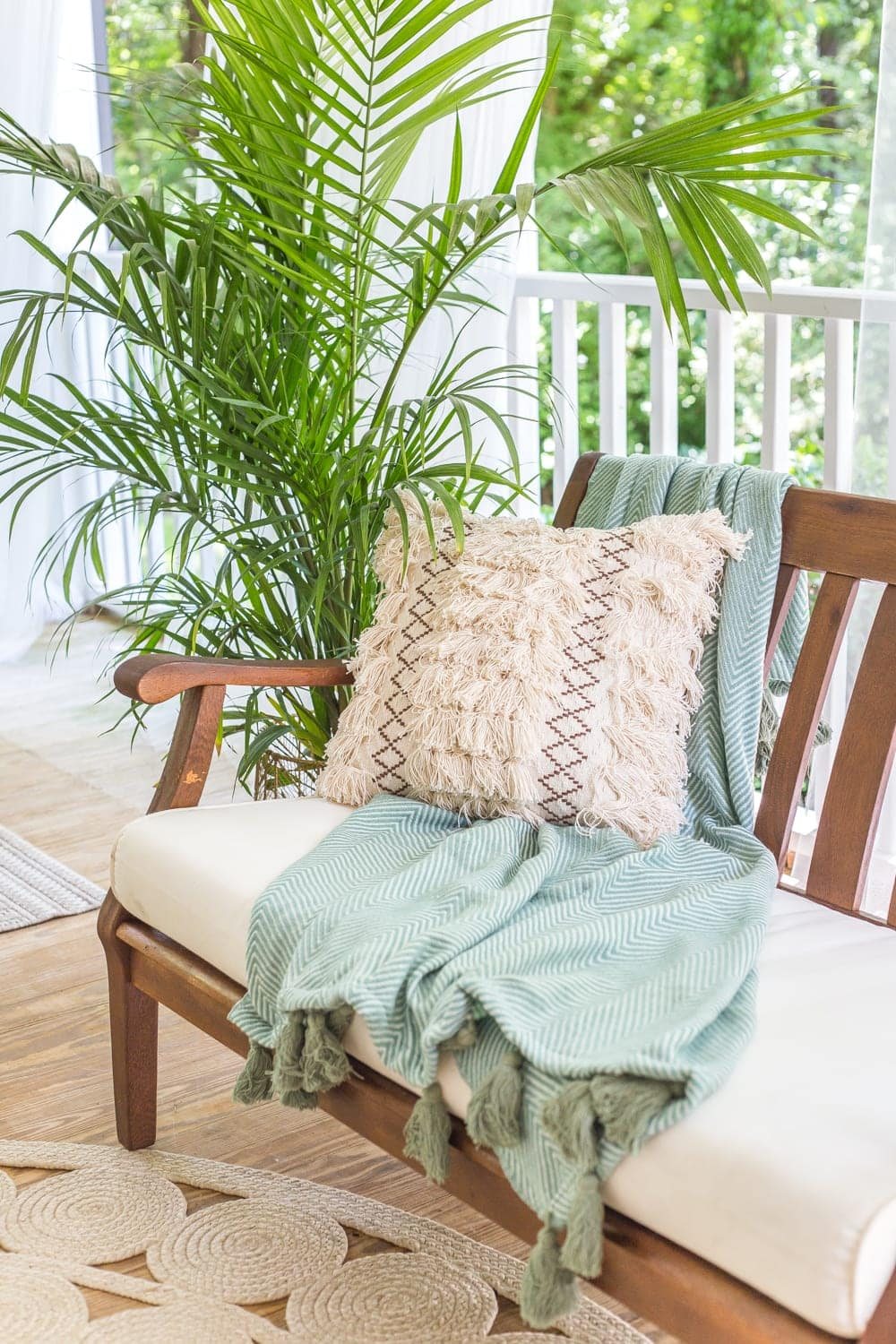 A tropical boho back porch decorated for summer with breezy, functional style from Walmart's Flower Home line by Drew Barrymore and string lights for evening ambience. #backporch #summerdecor