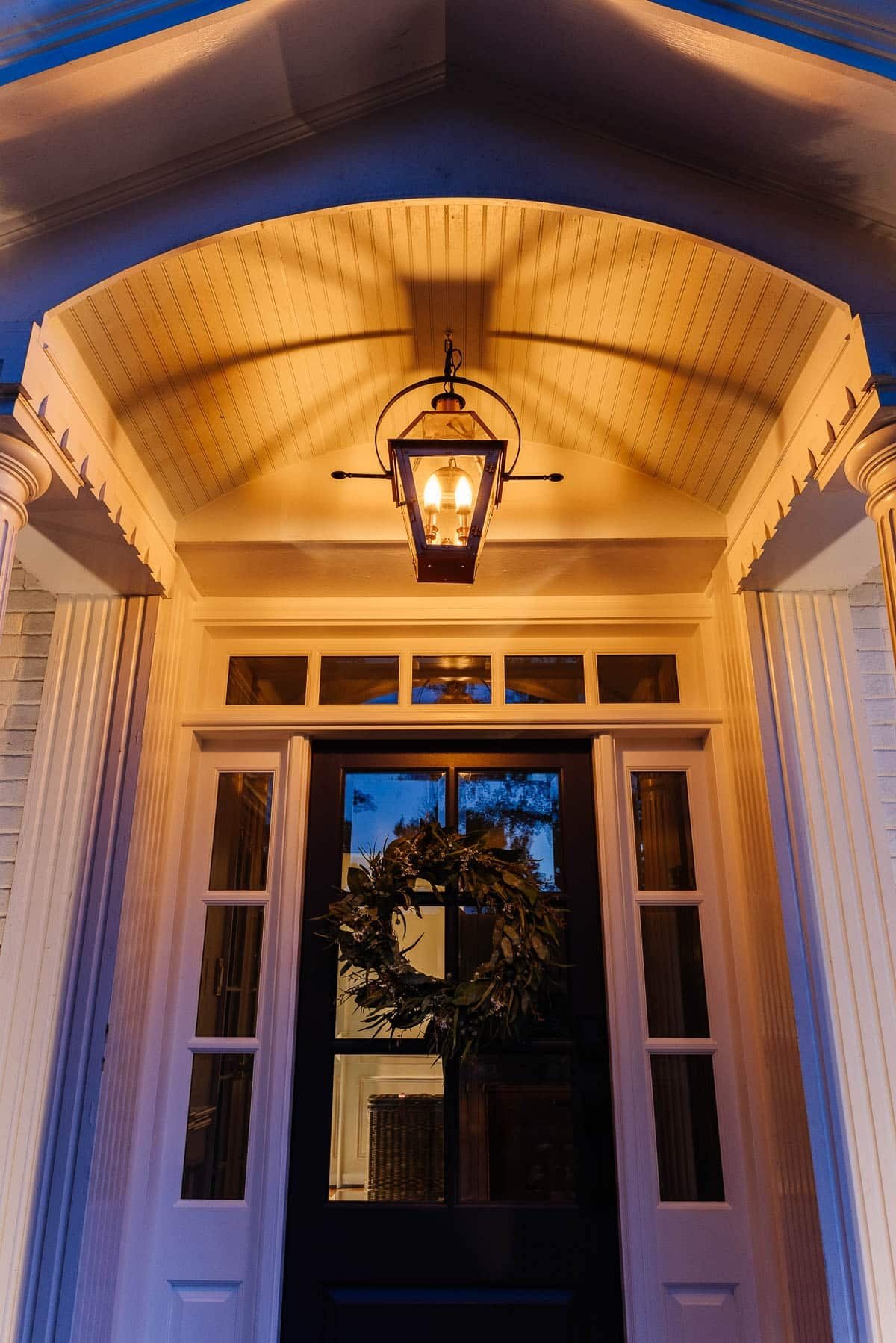 fake gas lantern on a front porch with flickering flame light bulbs at night