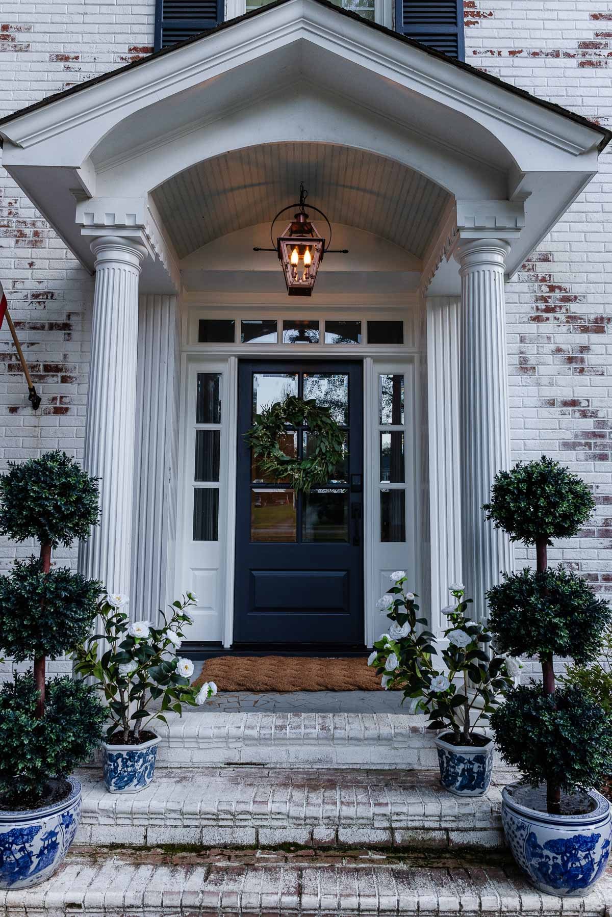 fake gas lantern on a front porch with flickering flame light bulbs at dusk