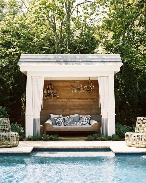 white pool cabana with rustic wood wall