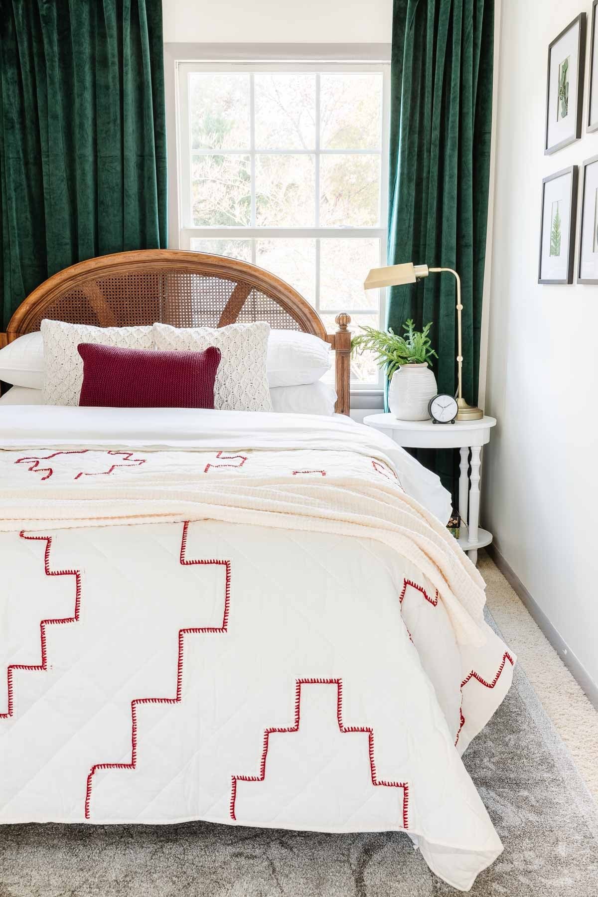 red and white stitched quilt with sweater knit pillows and green curtains