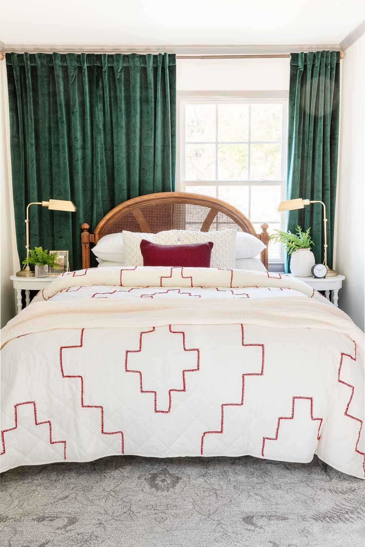 red and white stitched quilt with sweater knit pillows and green curtains
