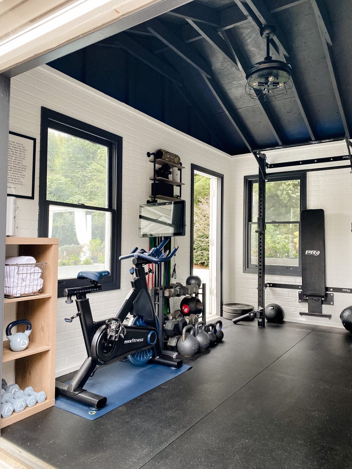 at home gym shed with cardio bike and weight lifting area