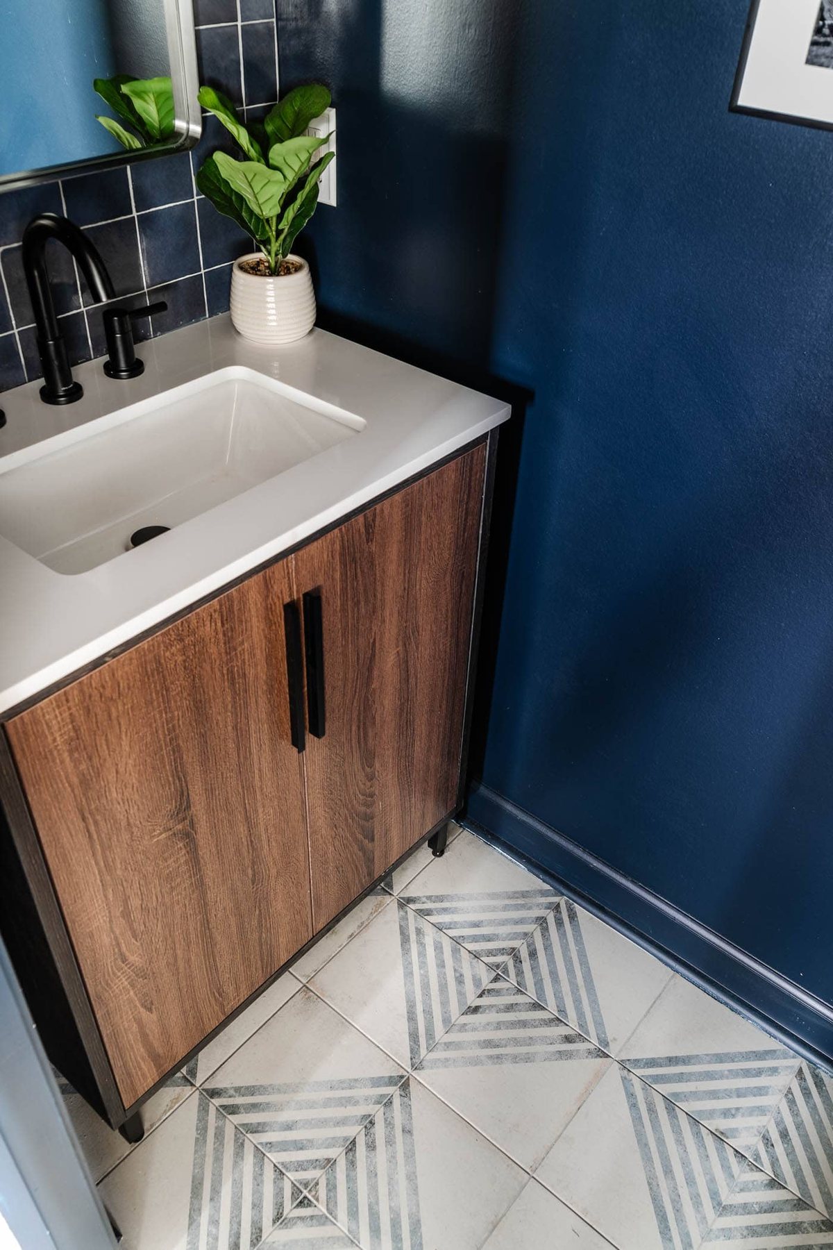 patterned tile and wood vanity with navy blue walls