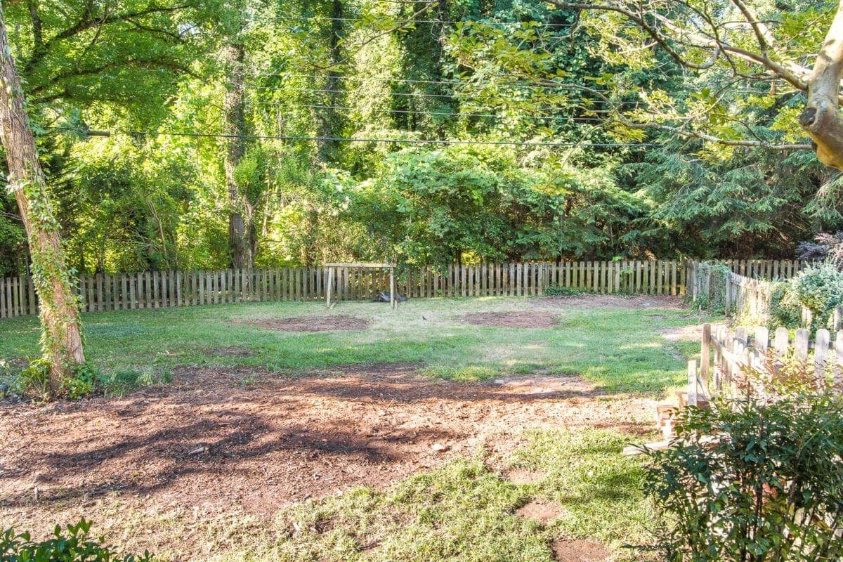 A before and after of backyard landscaping progress after overgrown brush and tree removal to create room for functional outdoor play.
