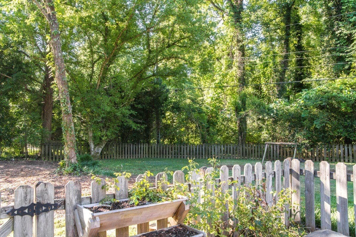 A before and after of backyard landscaping progress after overgrown brush and tree removal to create room for functional outdoor play.