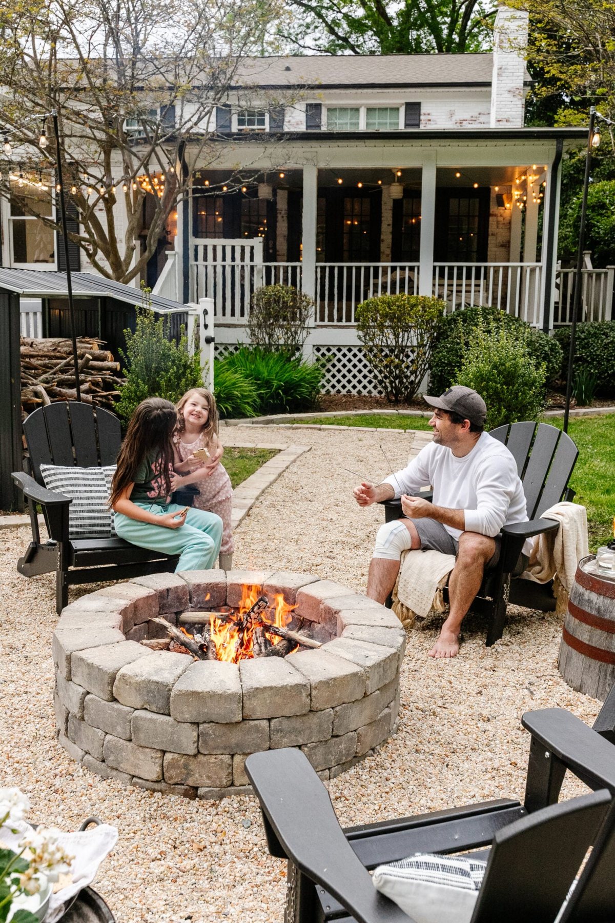 family sitting around a backyard fire pit
