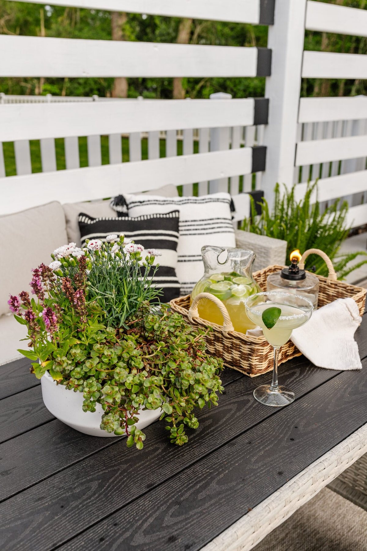 patio dining table with tray, tabletop tiki torch, margarita pitcher, and potted plant