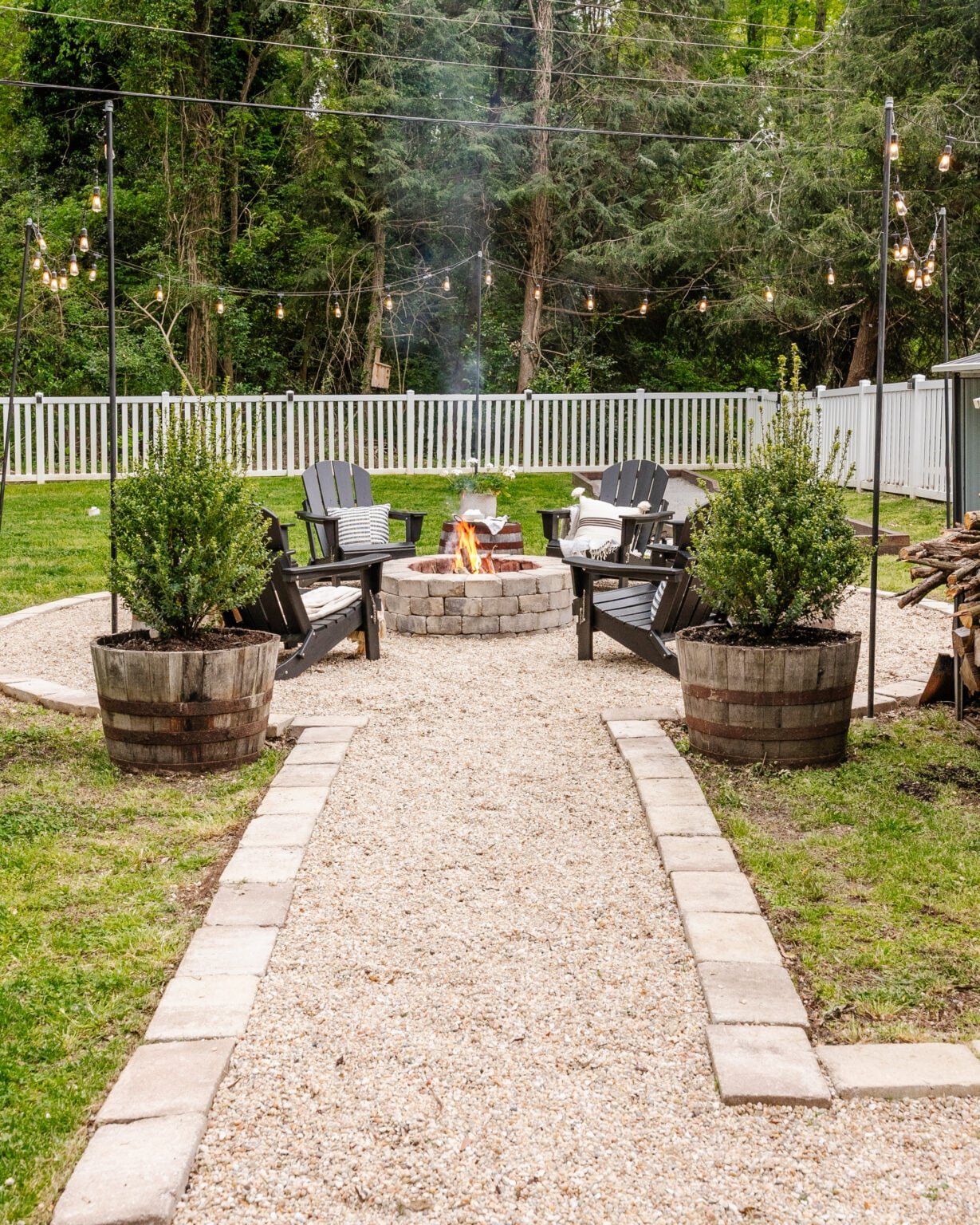 stone fire pit with pea gravel sitting area and adirondack chairs