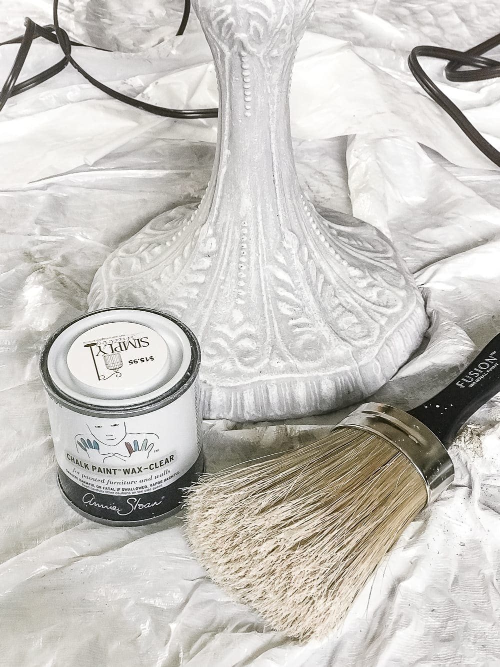 A thrifted table lamp gets a French Baroque designer inspired makeover using Annie Sloan Chalk Paint in Paris Grey, Pure White, clear wax, and dark wax. #thriftdecor #thrifted #thrifting #thriftmakeover #lamp #bedroom #girlbedroom #littlegirlbedroom #frenchdecor #femininedecor #designerknockoff #designerdecor