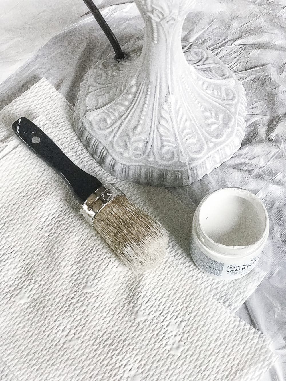 A thrifted table lamp gets a French Baroque designer inspired makeover using Annie Sloan Chalk Paint in Paris Grey, Pure White, clear wax, and dark wax. #thriftdecor #thrifted #thrifting #thriftmakeover #lamp #bedroom #girlbedroom #littlegirlbedroom #frenchdecor #femininedecor #designerknockoff #designerdecor