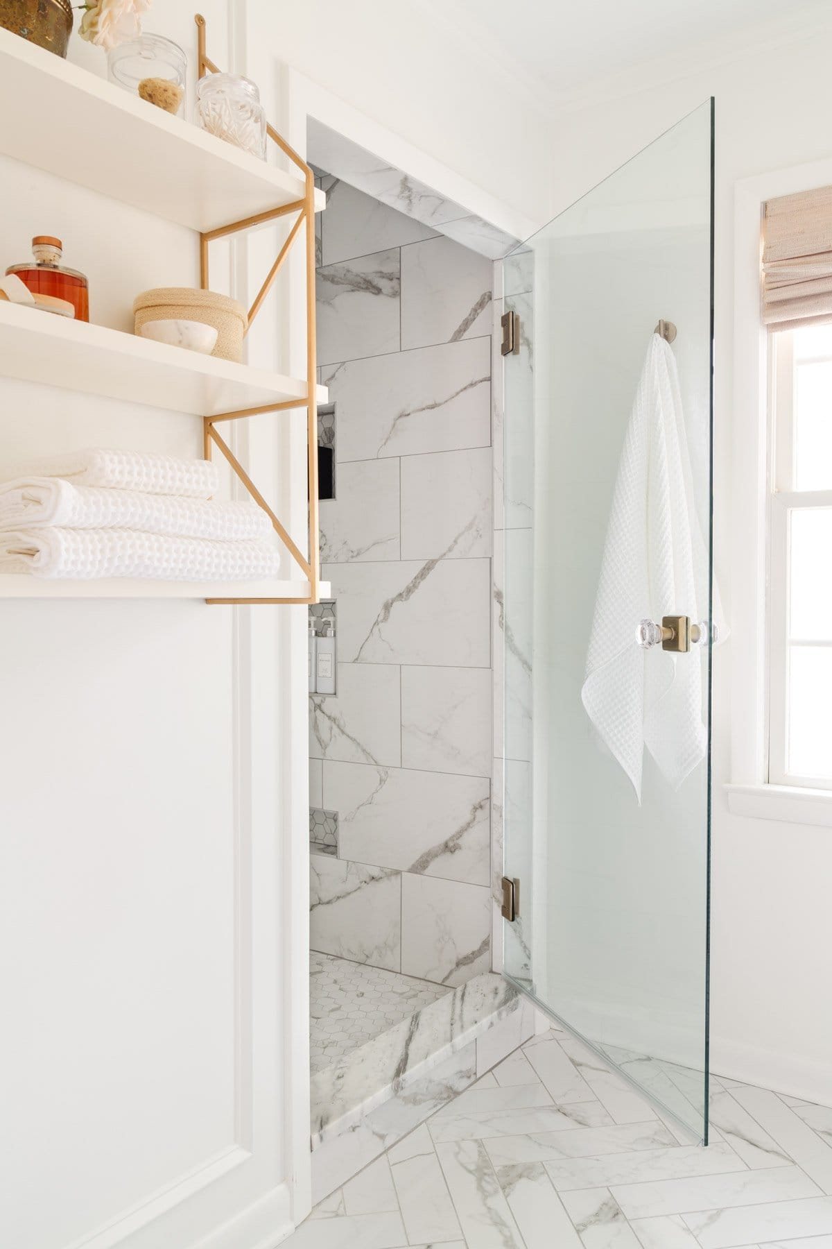 shower door with door knob and marble look tile
