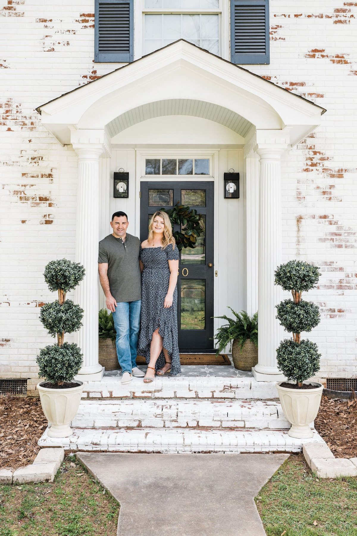 limewashed brick front porch stoop on a colonial house with boxwood topiaries