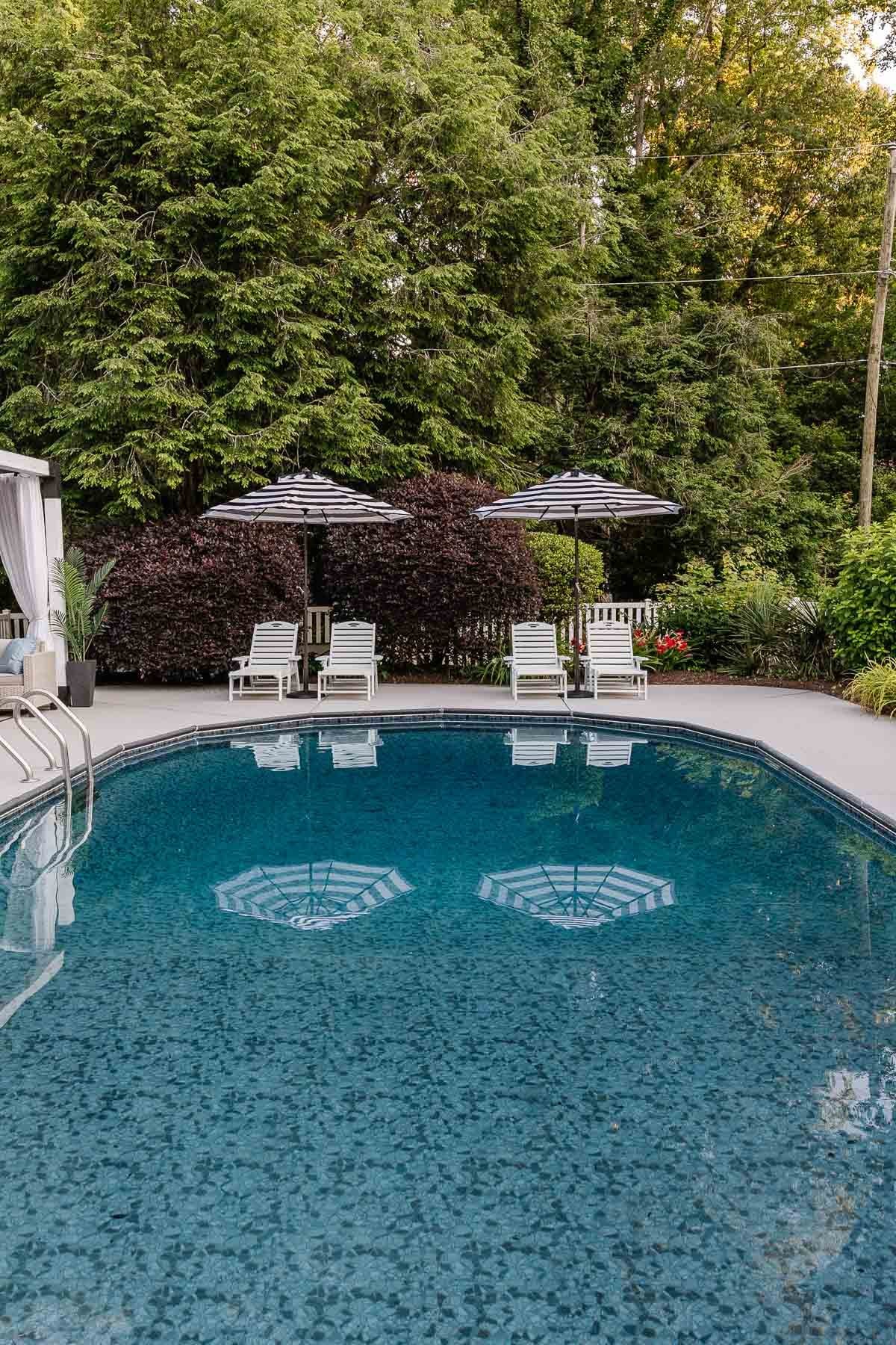 backyard pool with lounge chairs and umbrellas