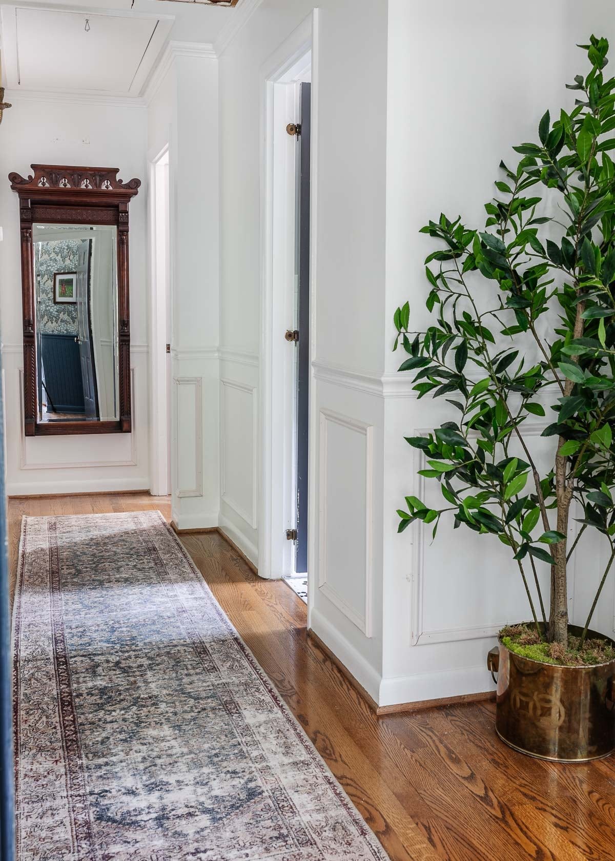 white hallway with full length antique mirror