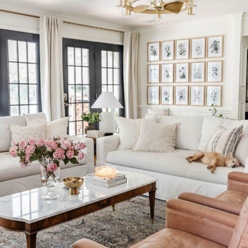 gold spray painted chandelier fan in a living room with white walls and black French doors