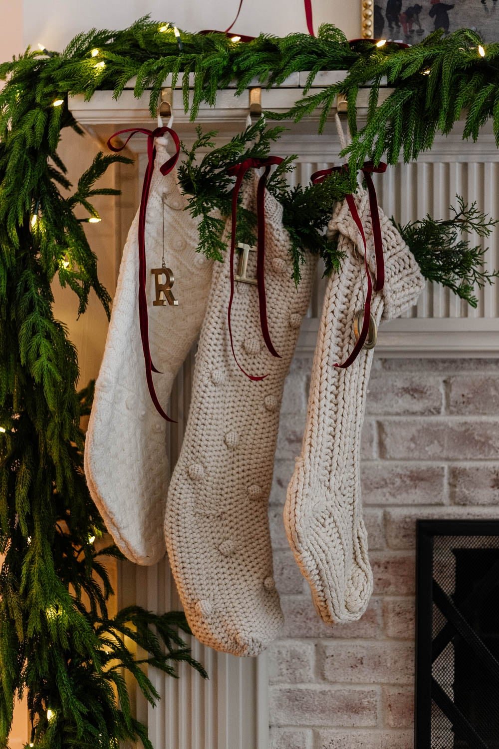 christmas stockings on a mantel with red ribbon