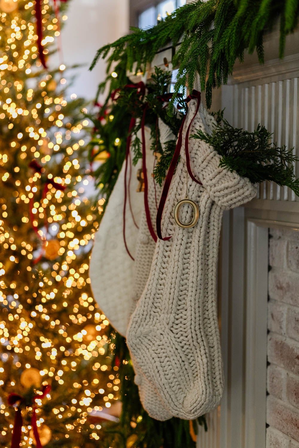 christmas stockings on a mantel with red ribbon