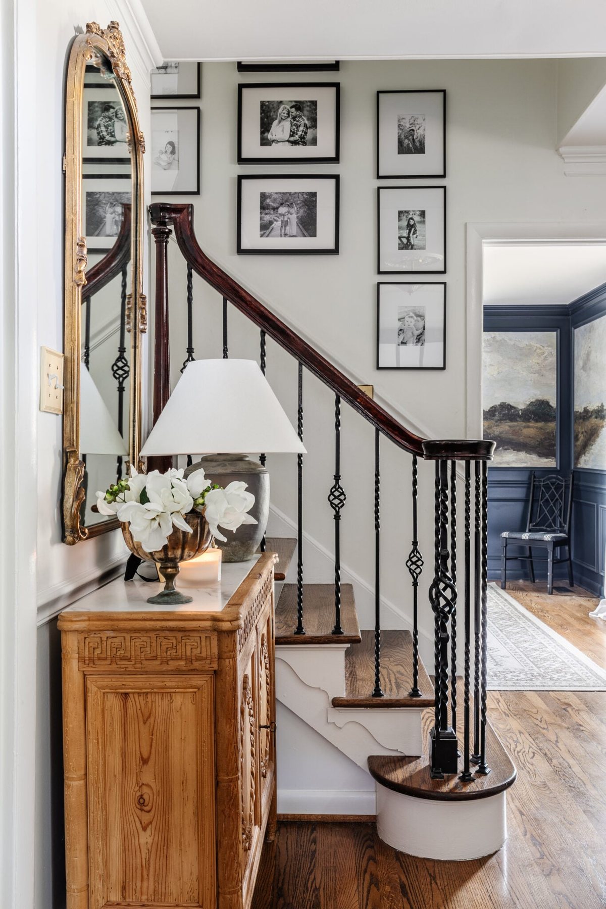 entryway staircase with black and white gallery wall