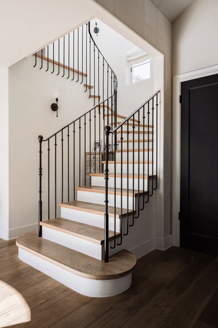 wrought iron black stair railing with white risers and wood treads
