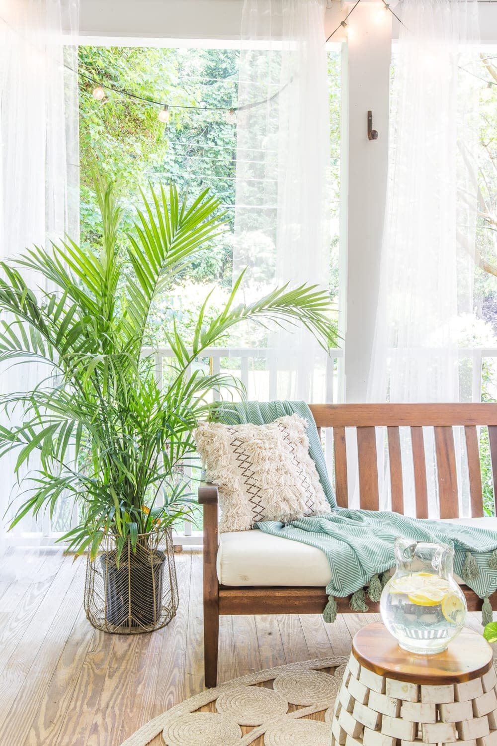 A tropical boho back porch decorated for summer with breezy, functional style from Walmart's Flower Home line by Drew Barrymore and string lights for evening ambience. #backporch #summerdecor