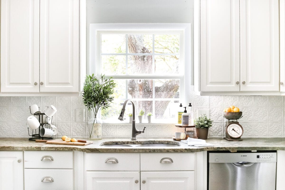 kitchen with white cabinets and sink in front of window