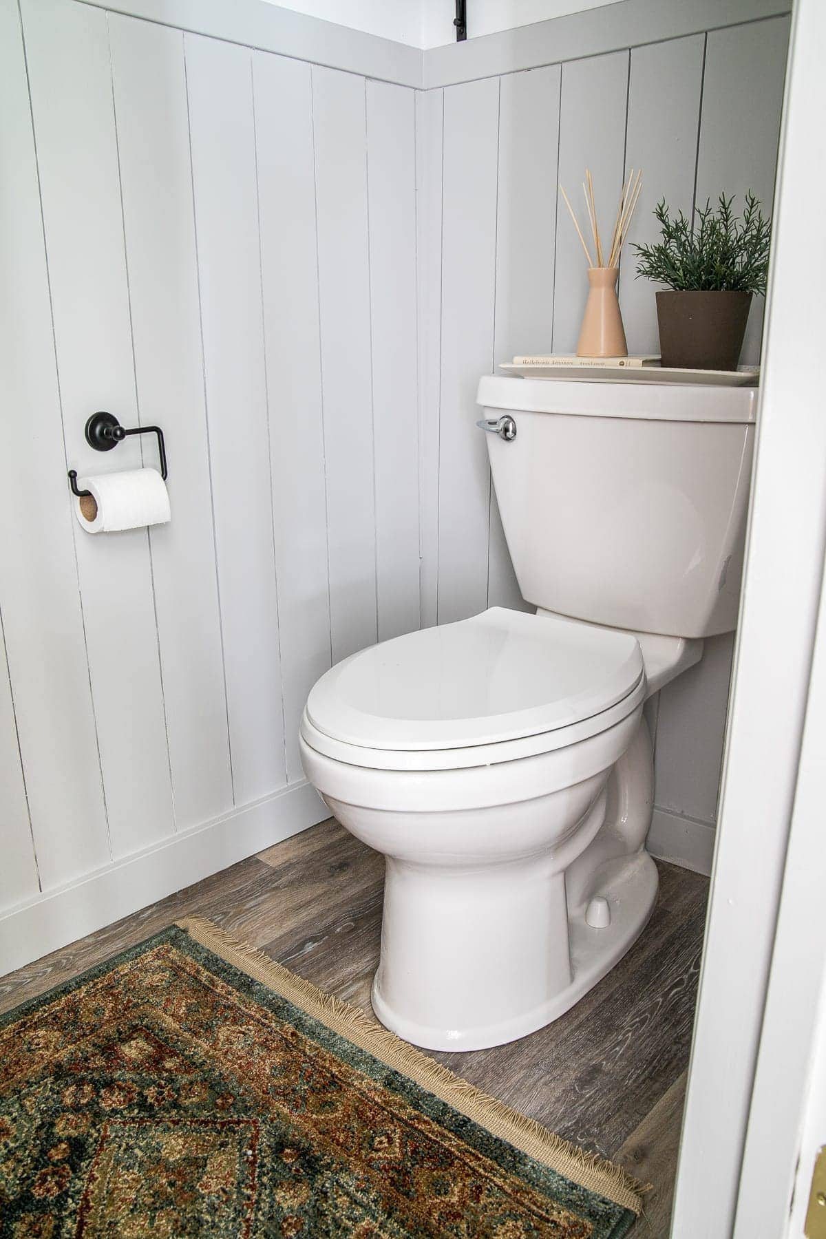 small bathroom with vertical shiplap and vintage style rug